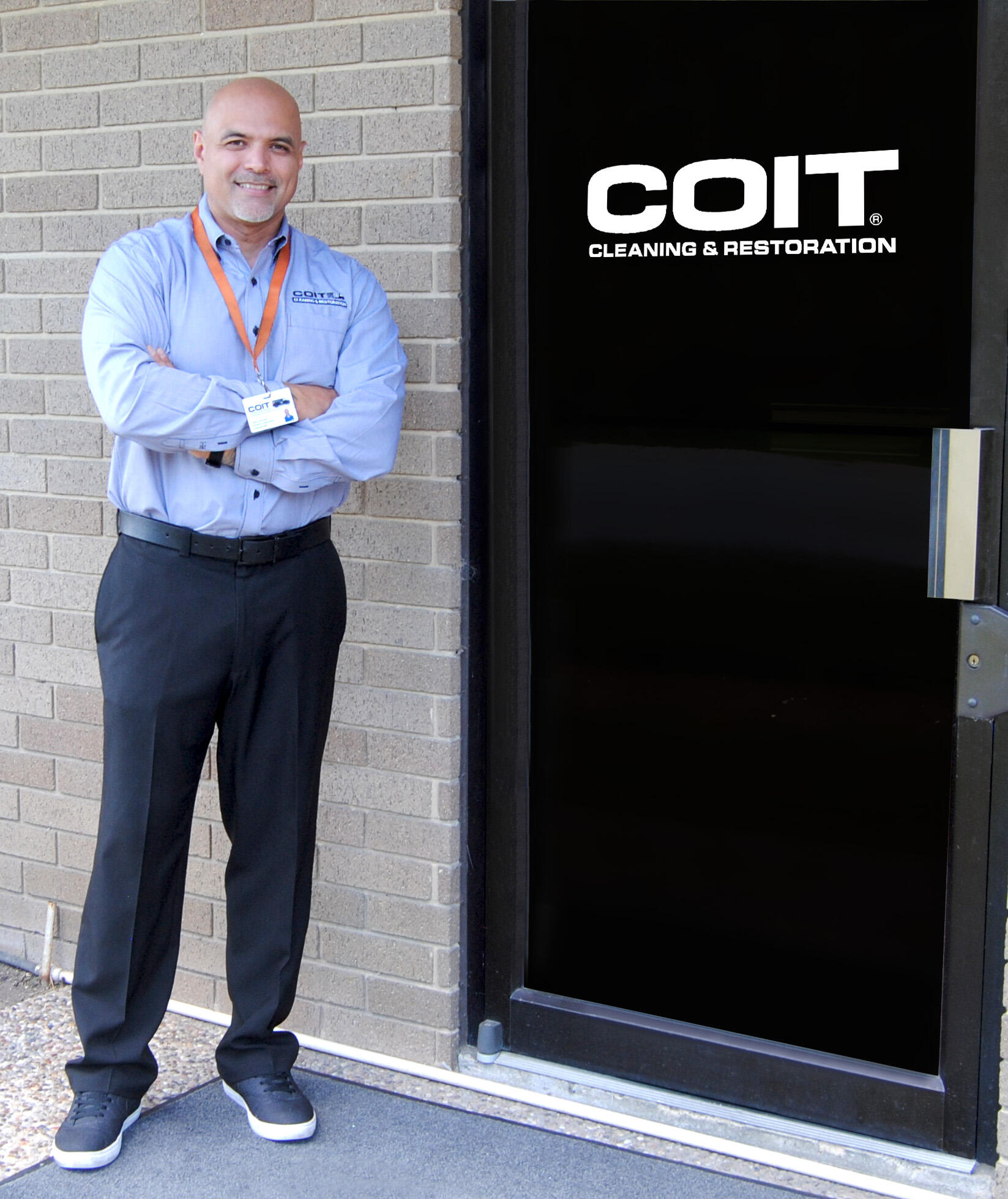 Robert standing next to black door with COIT logo